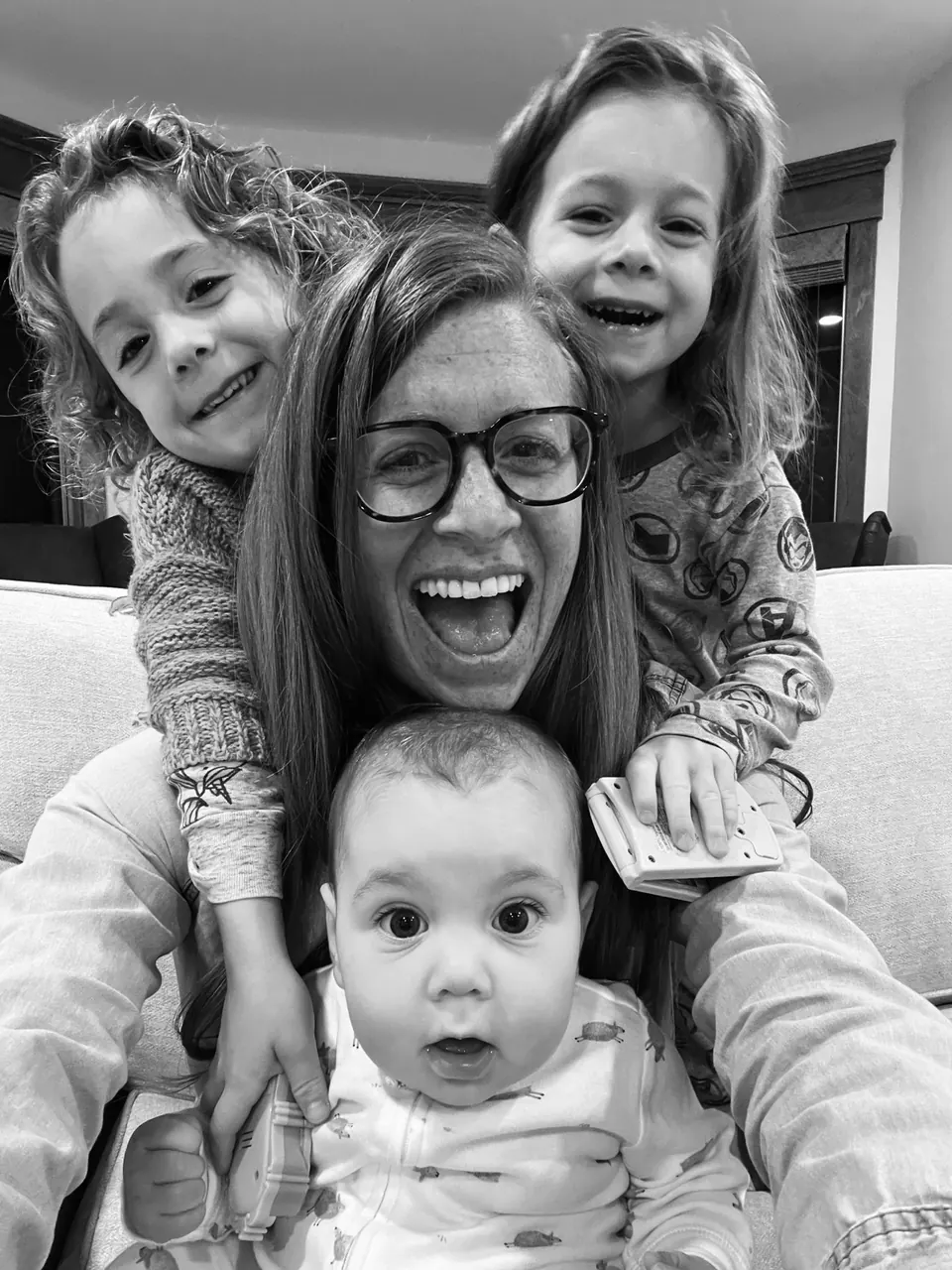 Kate with her three kids on the couch, black and white